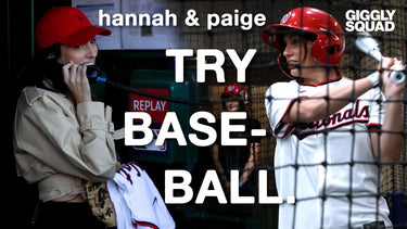 Two young women participating in a baseball-related activity.